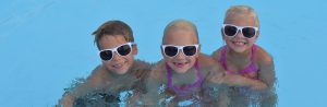 3 girls with sunglasses on having fun in pool