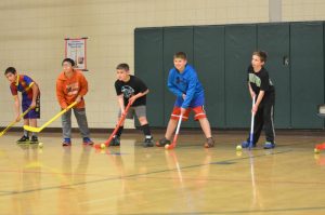 kids playing indoor floor hockey
