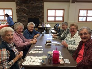 adults playing cards at friendship club