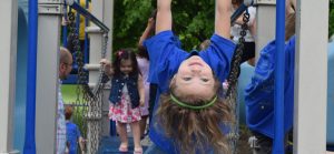 girl on playground equipment having fun