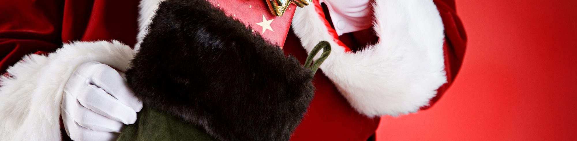 santa putting gift into stocking