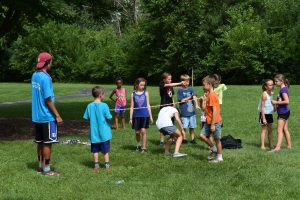kids doing limbo at summer camp