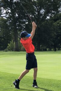 boy finishing golf swing