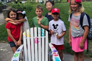 kids showing their art on the decorated chair