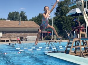 photo of young girl diving off diving board